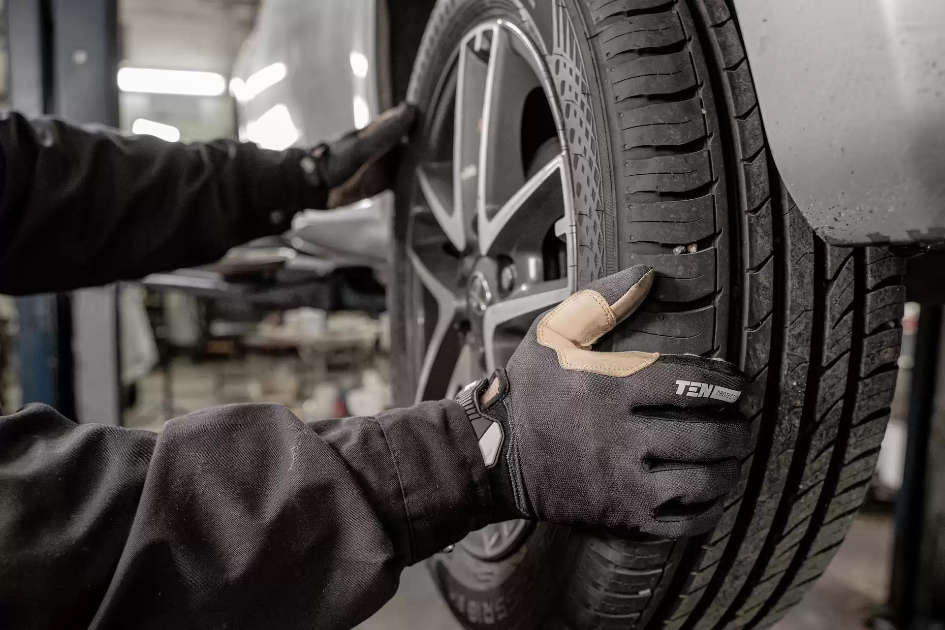 Automobile mechanic prepping a car tire for powder coating