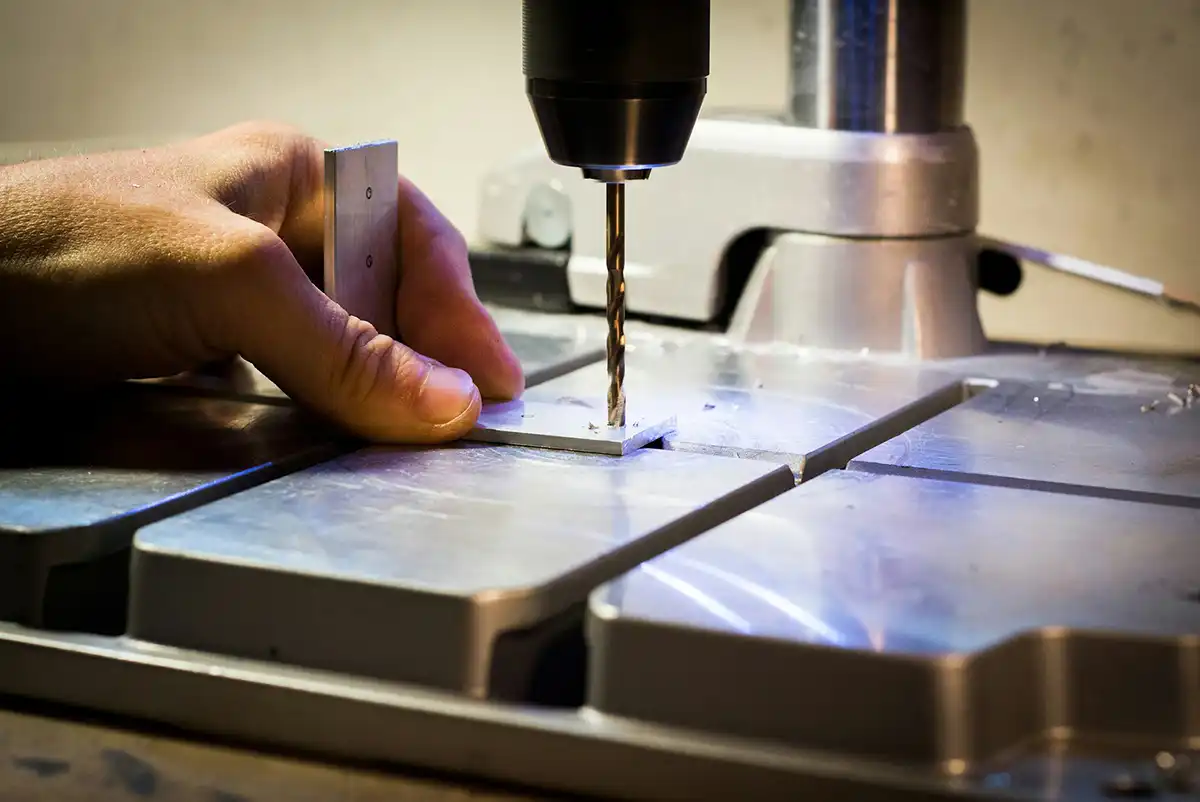 A man drilling metal bars.